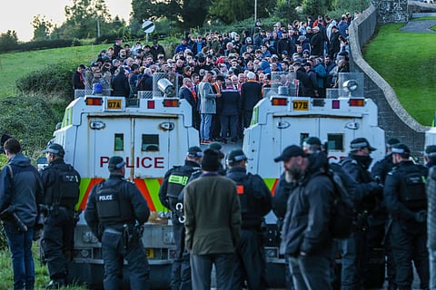Portadown Orangemen and supporters (top) gather at Drumcree Church after being stopped by police (bottom) from marching to Garvaghy Road, in Portadown, Northern Ireland on September 27, 2026.