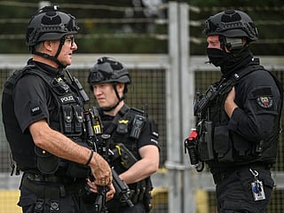 Armed police man a roadblock while posted at an entrance to RAF Fairford base in Fairford, south-west England on September 27, 2026, as UK counter-terrorism police investigate an incident near the base in the village of Whelford.