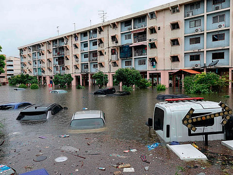 Flood waters submerge cars next to residential buildings after heavy rain in Bangkok.