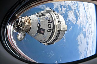 FILE - This photo provided by NASA shows Boeing's Starliner spacecraft docked to the International Space Station on July 3, 2024, seen from a window on the SpaceX Dragon Endeavour spacecraft docked to an adjacent port.