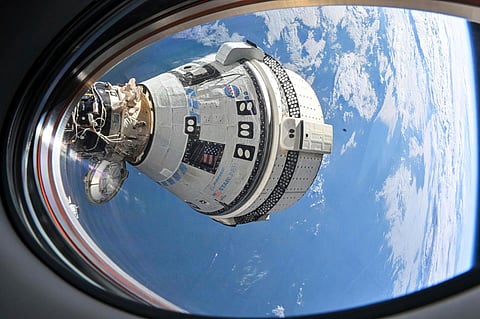 FILE - This photo provided by NASA shows Boeing's Starliner spacecraft docked to the International Space Station on July 3, 2024, seen from a window on the SpaceX Dragon Endeavour spacecraft docked to an adjacent port.