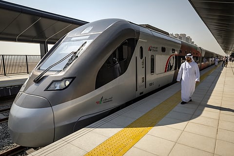 A man walks past an Etihad Rail train at Dubai's Yalayis station on September 29, 2026, during the inaugural passenger service connecting from Abu Dhabi's Mohamed Bin Zayed City station to Dubai.