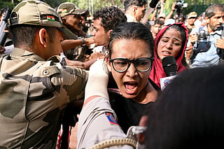 Police and security personnel detain All India Students' Association (AISA) President Neha Bora (C) during a protest against the country's Chief Election Commissioner Gyanesh Kumar in New Delhi on October 3, 2026, to demand his resignation over alleged irregularities in the Special Intensive Revision (SIR) of electoral rolls.