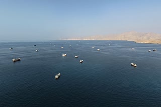 An aerial view shows ships anchored off the coast of Khasab in Oman’s Musandam Governorate, near the Strait of Hormuz, on October 2, 2026.