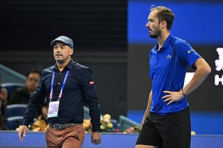 Russia's Daniil Medvedev (R) is escorted by an ATP official after Medvedev was disqualified for hitting a ball into the stands, injuring a spectator, during the men’s singles semi-final against Serbia’s Novak Djokovic at the China Open tennis tournament in Beijing on October 5, 2026.