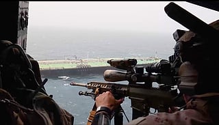 US Navy crew fly over a merchant vessels as part of operations to implement a naval blockade on Iranian ports.