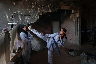 Palestinian youth take part in a Taekwondo training session inside a damaged building in Nuseirat, central Gaza Strip.