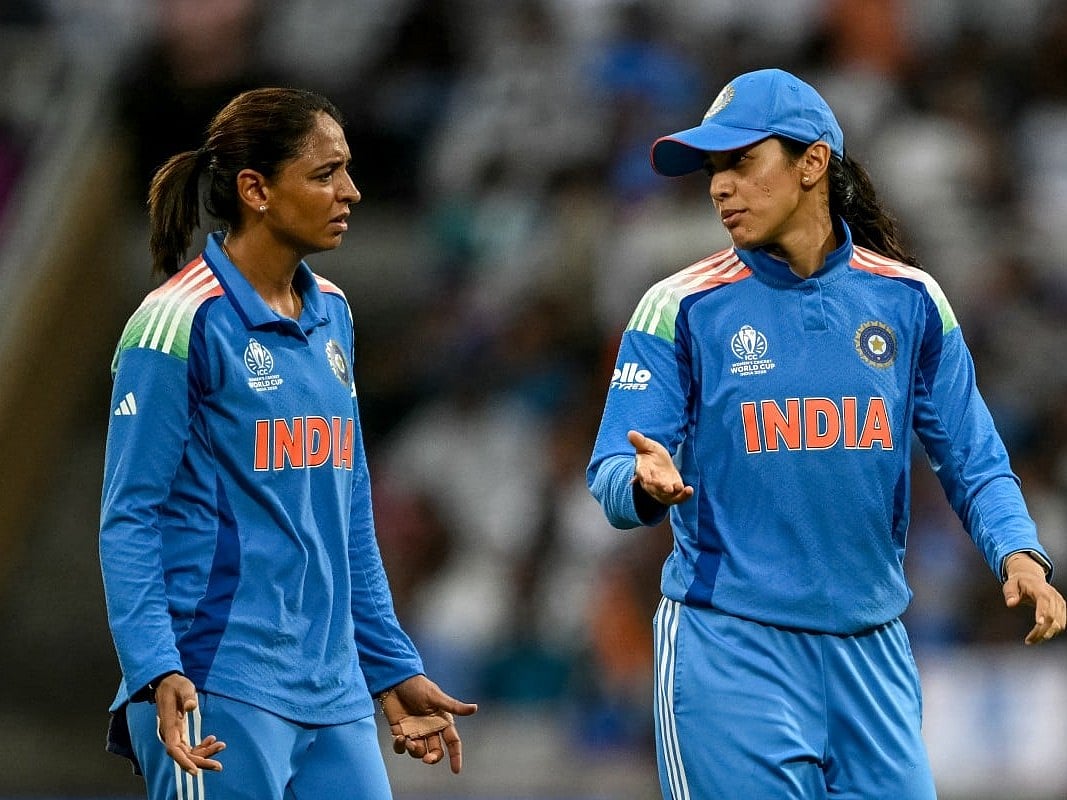 India's Smriti Mandhana (R) speaks with captain Harmanpreet Kaur during the ICC Women's Cricket World Cup 2025 one-day international (ODI) match between India and Bangladesh at the DY Patil Stadium in Navi Mumbai on October 26, 2025.