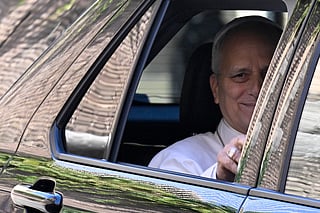 Pope Leo XIV waves from the window of the car as he leaves the Vatican before being admitted to Rome's Gemelli University Hospital for an operation to remove a lump from his lung, in the Vatican on 13 October 2026.