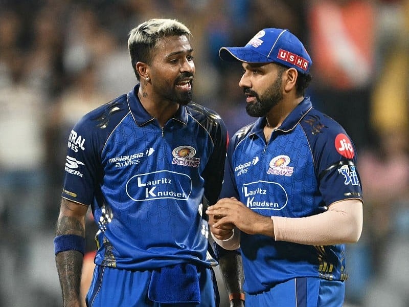 Mumbai Indians' captain Indian cricket player Hardik Pandya (L) speaks with teammate India's Rohit Sharma during the 2026 Indian Premier League (IPL) T20 match between Mumbai Indians and Royal Challengers Bengaluru at the Wankhede Stadium in Mumbai on April 12, 2026.