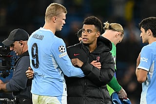 Manchester City's Norwegian striker #09 Erling Haaland (L) and Paris Saint-Germain's French midfielder #14 Desire Doue (C) chat on the pitch after the UEFA league-phase football match between Manchester City and PSG at the Etihad Stadium in Manchester, northwest England, on October 14, 2026.