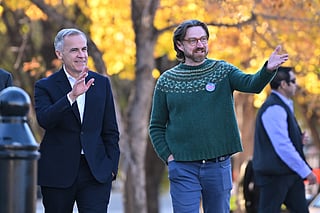 Prime Minister Mark Carney, left, arrives with Executive Director of Public Interest Alberta Brad Lafortune to meet volunteers at Bridgeland Riverside Community Association Park in Calgary, Alberta, on Thursday Oct. 15, 2026. 