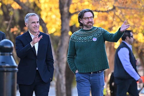 Prime Minister Mark Carney, left, arrives with Executive Director of Public Interest Alberta Brad Lafortune to meet volunteers at Bridgeland Riverside Community Association Park in Calgary, Alberta, on Thursday Oct. 15, 2026. 