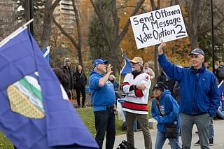 A man holds up a sign during an Alberta Independence Rally in Edmonton, Alberta, Canada on October 17, 2026.