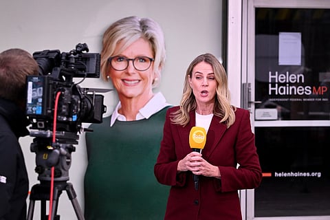 A TV crew works in front of a portrait of Australian politician Helen Haines (C) outside her office in the northern regional city of Wangaratta, about 250 kilometres north-east of Melbourne on October 20, 2026.