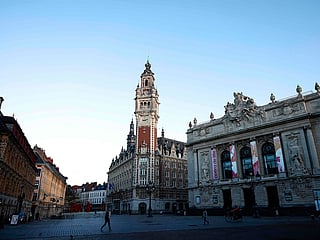 Pedestrian walk past the Opera of Lille and Belfry of the Lille Chamber of Commerce, in Lille, northern France.