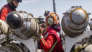 US Navy personnel handle aviation ordnance aboard an aircraft carrier in an image supplied by US Central Command. The ship’s name, location and date were not independently verified. 
