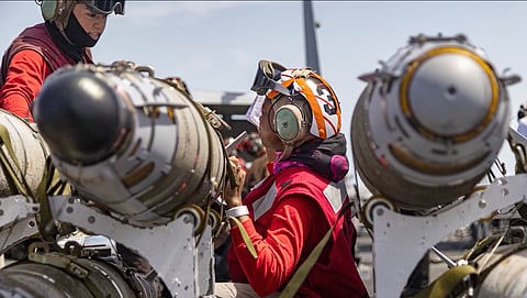 US Navy personnel handle aviation ordnance aboard an aircraft carrier in an image supplied by US Central Command. The ship’s name, location and date were not independently verified. 
