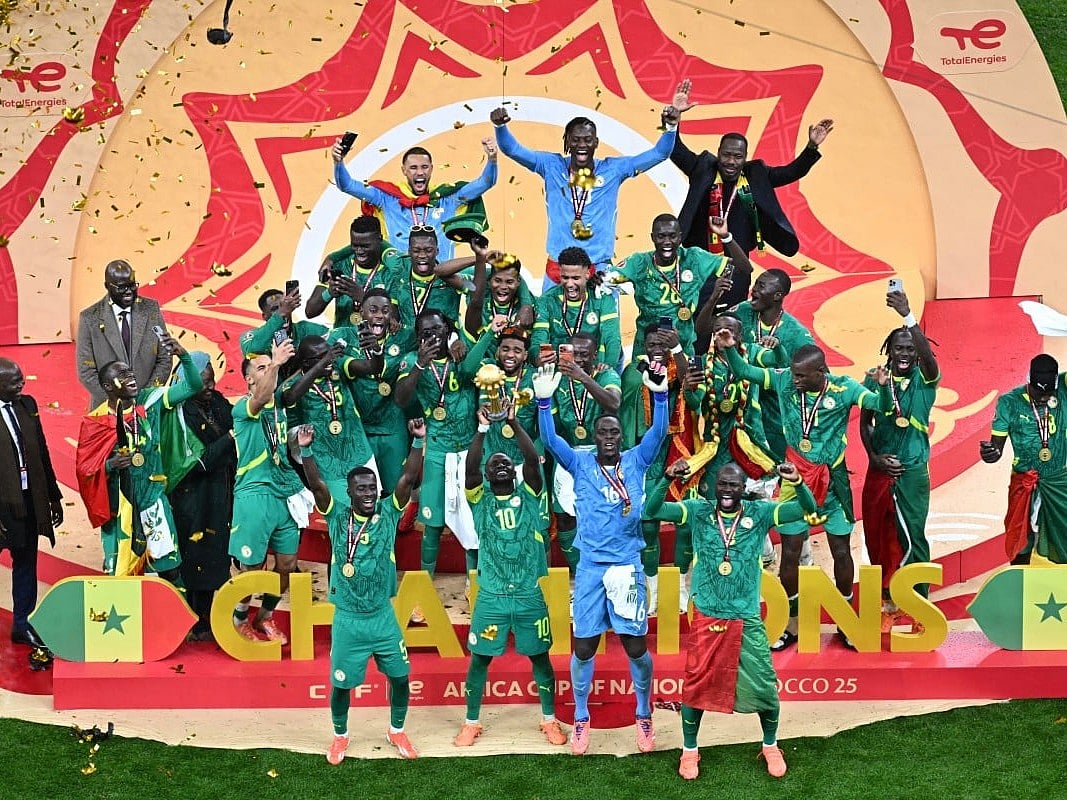 Senegal players celebrate with the trophy after winning the Africa Cup of Nations (CAN) final football match against Morocco at the Prince Moulay Abdellah Stadium in Rabat on January 18, 2026.