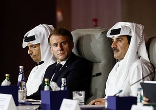 France's President Emmanuel Macron, flanked by Qatar's Prime Minister Sheikh Mohammed bin Abdulrahman al-Thani (L) and Qatar's Emir Sheikh Tamim bin Hamad al-Thani, attends the 9th Annual One Planet Sovereign Wealth Funds (OPSWF) Summit at the Rosewood Hotel in Lusail on October 21, 2026.