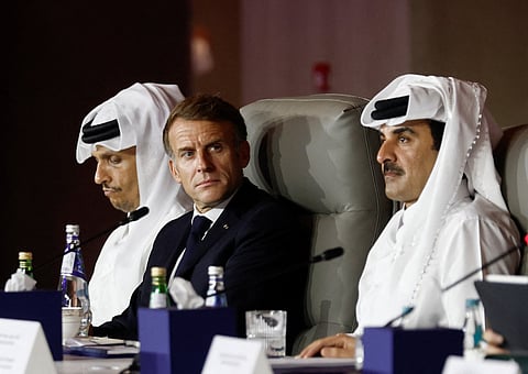 France's President Emmanuel Macron, flanked by Qatar's Prime Minister Sheikh Mohammed bin Abdulrahman al-Thani (L) and Qatar's Emir Sheikh Tamim bin Hamad al-Thani, attends the 9th Annual One Planet Sovereign Wealth Funds (OPSWF) Summit at the Rosewood Hotel in Lusail on October 21, 2026.