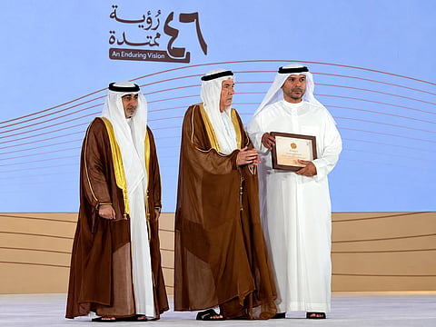 Daeij Khalaf Al Karab Al Ali (right) receives the academic excellence certificate of his daughter Bainah from Zaki Nusseibeh on Thursday