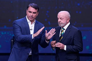 Opposition presidential candidate Sen. Flavio Bolsonaro, left, raises his hands as Brazilian President Luiz Inacio Lula da Silva, who is running for reelection, looks on during a televised presidential debate one week before the presidential runoff election in Sao Paulo, Brazil, Sunday, Oct. 18, 2026. (AP Photo/Andre Penner)