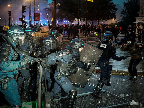 French Police in riot gear operate during a demonstration in favor of purchasing power, the protection of public services, and fiscal and social justice, in Paris on October 24, 2026 as part of a nationwide call for mobilisation bringing together former members of the Yellow Vest movement, labour unions, high school and university students. 