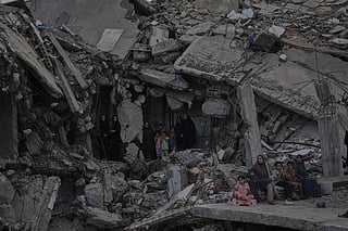 Palestinian women and children watch the Palestine Strongman Championship from among the rubble of destroyed buildings in Gaza City.