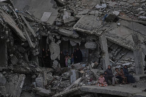 Palestinian women and children watch the Palestine Strongman Championship from among the rubble of destroyed buildings in Gaza City.