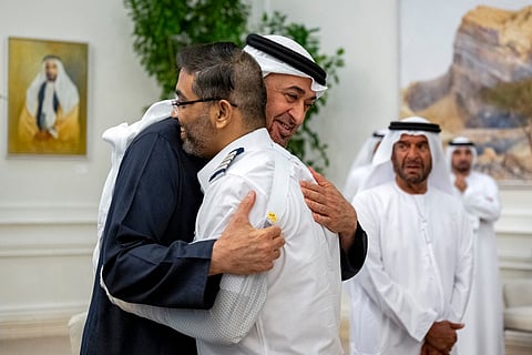 This handout picture provided by the UAE Presidential Court shows UAE President Sheikh Mohamed bin Zayed Al-Nahyan embracing Flydubai pilot Smit Machchhar, during a reception for him and other crew members of Flight 1073 in Abu Dhabi on October 27, 2026.