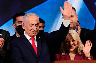 Israeli Prime Minister Benjamin Netanyahu, accompanied by his wife, Sara, waves to supporters at Likud party headquarters in Jerusalem after the release of the first exit poll results in Israel's general election, Wednesday, Oct. 28, 2026. (AP Photo/Ohad Zwigenberg)