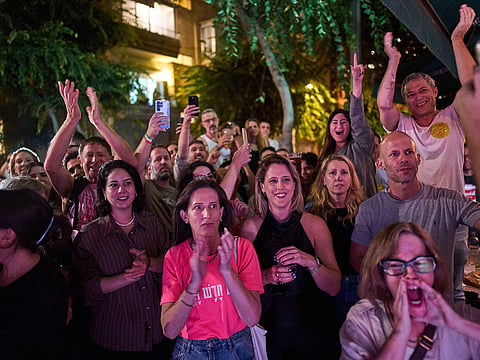 People react as they watch the exit polls for Israel's general election in Tel Aviv, Israel.