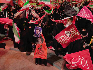 Demonstrators wave flags as one holds up a portrait of the Iranian Supreme Leader Ayatollah Mojtaba Khamenei during a pro-government gathering in Tehran. 