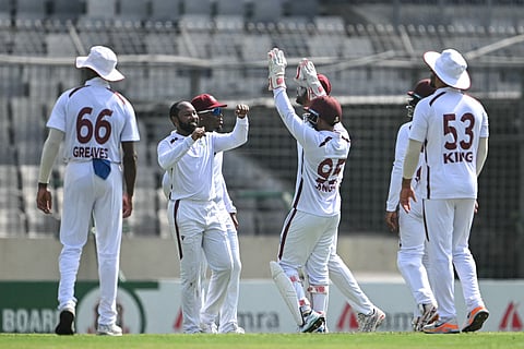 West Indies' Jomel Warrican (2L) celebrates with teammates after taking the wicket of Bangladesh's Mehidy Hasan Miraz during the second day of the first Test against Bangladesh at the Sher-e-Bangla National Stadium in Mirpur on October 29, 2026.