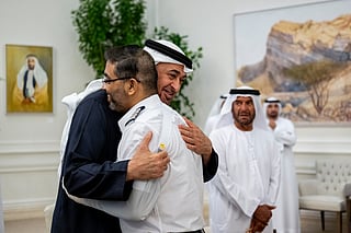 This handout picture provided by the UAE Presidential Court shows UAE President Sheikh Mohamed bin Zayed Al-Nahyan embracing Flydubai pilot Smit Machchhar, during a reception for him and other crew members of Flight 1073 in Abu Dhabi on October 27, 2026.