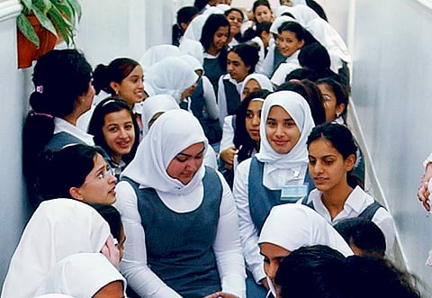 Pupils from Kuwait’s Qurtuba secondary school for girls sit in a hall.
