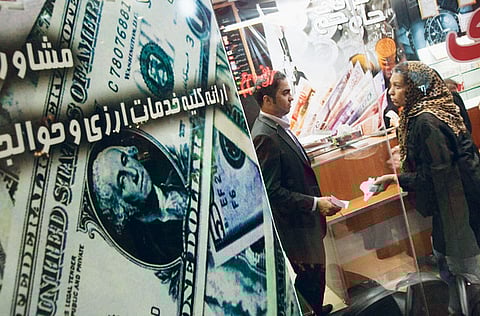 A woman talks to a currency exchange dealer in northern Tehran. Iranian Central Bank governor Abdolnaser Hemmati said he would defend Iran's ailing currency against speculation without injecting hard cash into the market.
