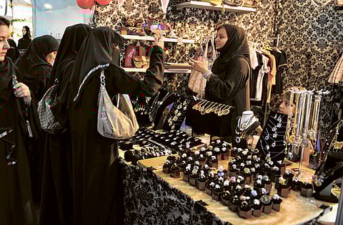 Visitors examine accessories displayed at an exhibition for young Saudi entrepreneurs in Jeddah. Banned from driving and denied the right to travel without permission, Saudi women are taking bold steps in business and trying to do away with the male guardian system that hobbles them.