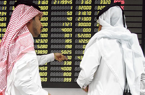 Traders study an electronic share price display at the Doha Stock Exchange in Qatar. The shares of QLM Life & Medical Insurance Co. jumped as they debuted on Qatar's stock exchange on Wednesday.
