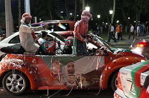 Emirati youth take to the roads of Abu Dhabi to celebrate UAE National Day with a decorated car displaying the portraits of the UAE's rulers and colours of the national flag. 