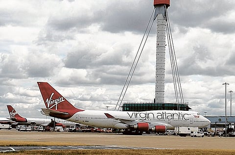 A Virgin Atlantic aircraft sits on the tarmac in front of the control tower at Heathrow airport in London.