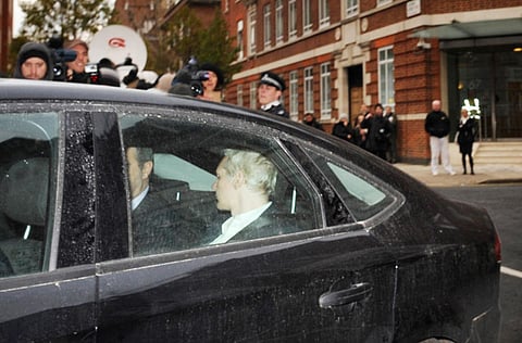 WikiLeaks founder Julian Assange (back to camera)  is driven into Westminster Magistrates Court in L