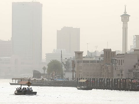 Abras cross the Dubai Creek amid cold, hazy conditions.