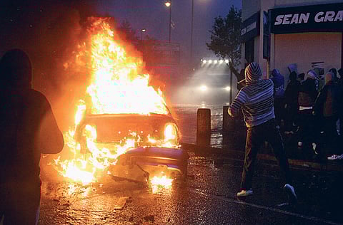 Irish nationalist rioters burn a hijacked car in the Ardoyne area of North Belfast, Northern Ireland.