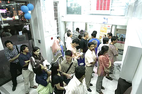 Customers form a queue at a money remittance centre in Dubai. 