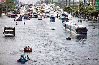 Vehicles are parked on an elevated highway to avoid rising flood waters north of Bangkok on Tuesday. Thailand announced a five-day holiday on Tuesday to give people to the chance to escape floods closing in on Bangkok. 