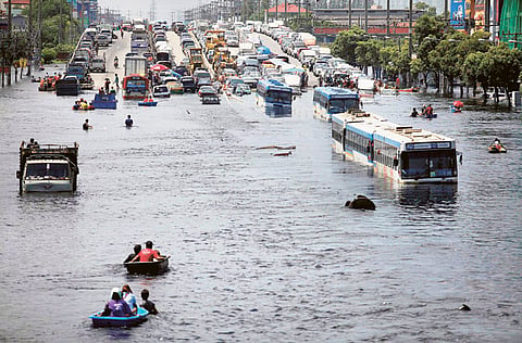 Vehicles are parked on an elevated highway to avoid rising flood waters north of Bangkok on Tuesday. Thailand announced a five-day holiday on Tuesday to give people to the chance to escape floods closing in on Bangkok. 