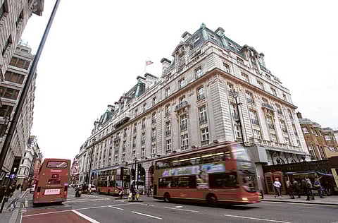 Buses pass by the Ritz hotel in London. 