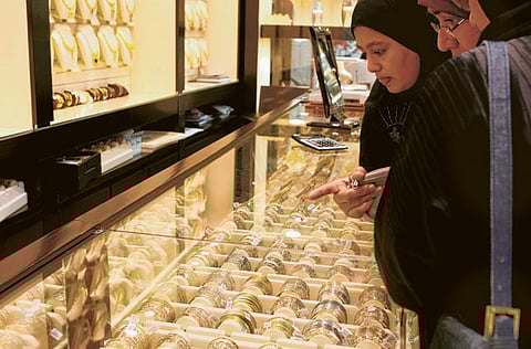 Customers select gold bracelets at a shop in the Dubai Gold Souq. [File image]